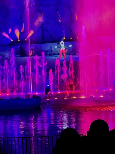 Mickey Mouse performs at Hollywood Studios Fantasmic! with colorful fountains.