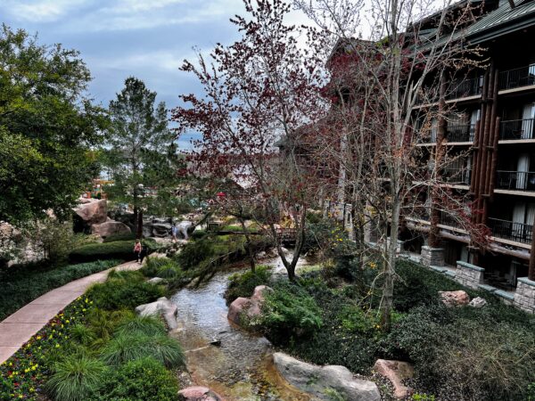 Disney's Wilderness Lodge resort with stream, lush greenery, and lodge building