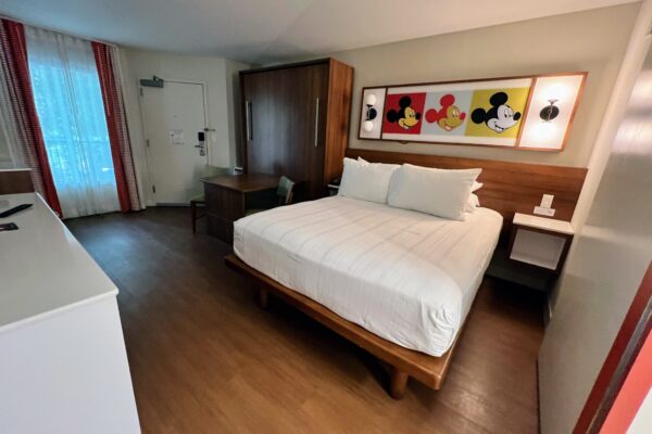 Disney resort room with Mickey Mouse art and queen bed