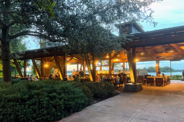 Covered outdoor bar and dining area at a Disney World resort with lake view