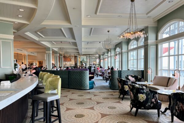 Elegant dining room with patterned floors, plush seating, and large windows.
