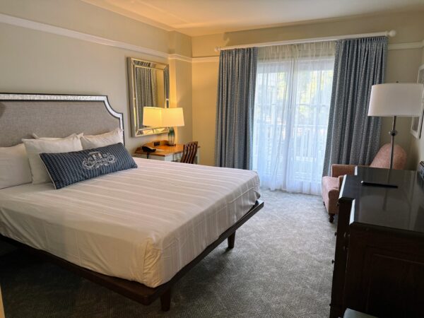 Hotel room with king bed, desk, and balcony view