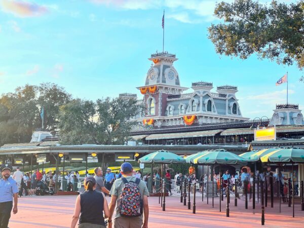 Guests enter Magic Kingdom at Walt Disney World, with Cinderella Castle visible.