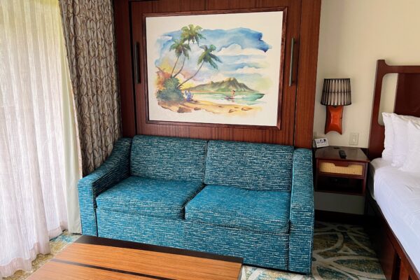 DVC resort room with pull-out sofa, bed, and tropical art