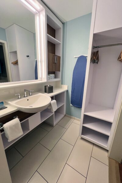Disney room bathroom with sink, closet, and ironing board