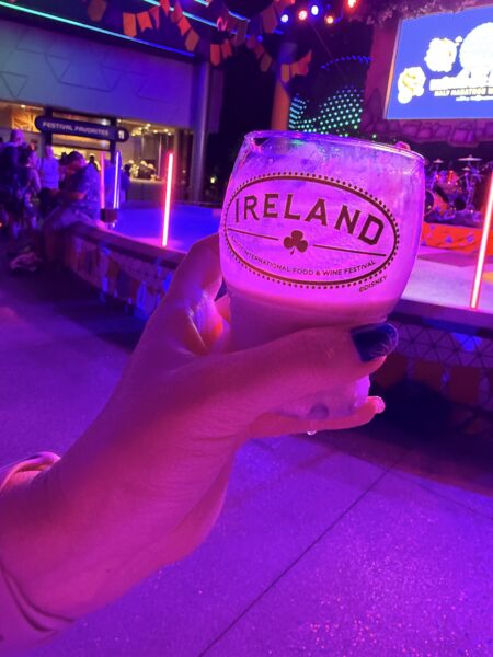 Hand holding a drink with "Ireland" and "Food & Wine Festival" text at night