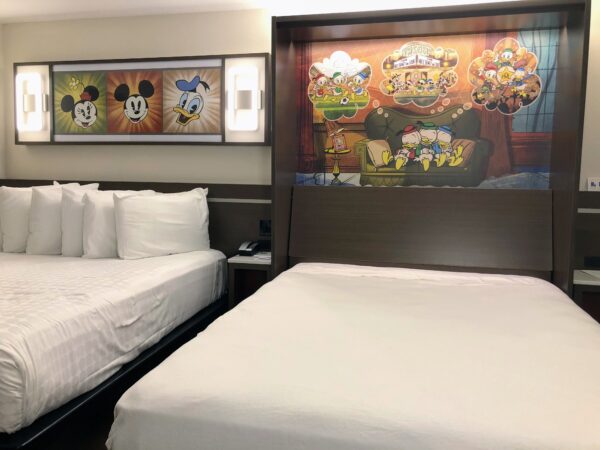 Disney hotel room with two beds and Mickey Mouse artwork