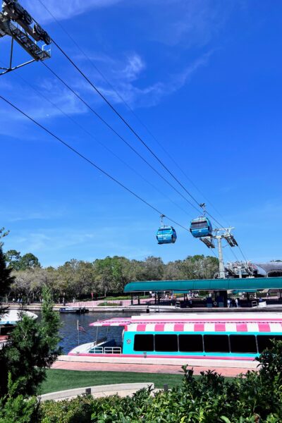 Disney World Skyliner gondolas over a boat dock with a colorful boat